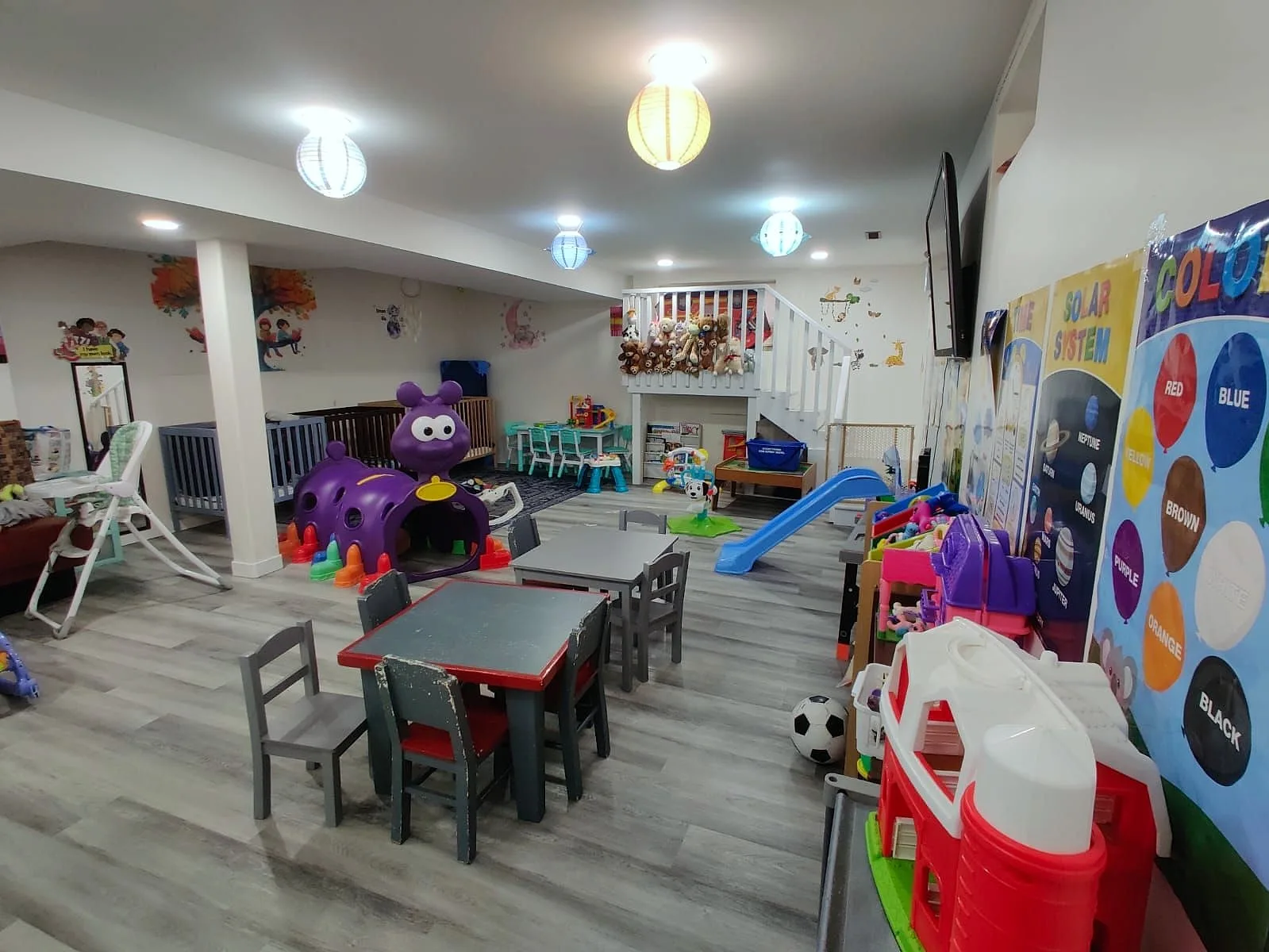 Our bright playroom with tables, a tunnel, a slide and lots of toys.
